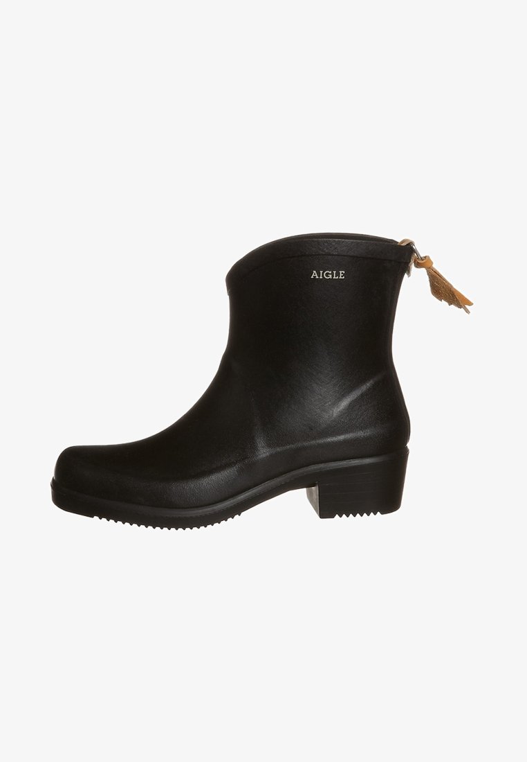 Bottes noires pour cheville en caoutchouc à surface lisse, talon bloc bas, avec un logo doré "AIGLE" sur le côté. Elles comportent un ornement à pampilles.
