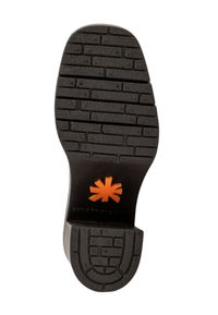 Semelle de chaussure en caoutchouc noir avec un motif texturé en briques. Présente un logo orange en relief au centre et un design de bout arrondi.