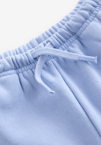 Hellblaue Jogginghose mit elastischem Bund und Kordelzug. Weiche Textur und glatte Oberfläche, ideal für Freizeitkleidung.