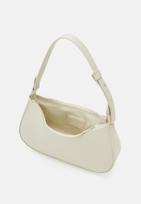 Béžová kabelka z hladkého materiálu, vybavená zipovým uzávěrem, zaobleným tvarem a jedním nastavitelným popruhem. Vnitřek je podšitý světlejším materiálem.