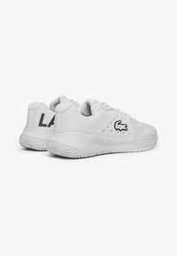 Scarpe da ginnastica bianche con tomaia testurizzata, design con lacci e dettaglio del logo. Presentano un "LA" nero a contrasto sul tallone e una soletta decorata.