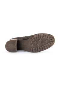Brown suede shoe sole with a textured grip. Features a square heel and a slight curve at the toe. Reinforced with patterned tread for traction.