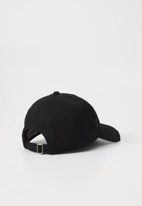 Black cotton baseball cap with a curved brim, adjustable strap at the back, and embroidered logo detail on the side. Textured fabric.