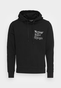 Sudadera negra con bolsillo frontal, cordones y texto gótico blanco "Replay Super Charged" en el área del lado izquierdo del pecho.