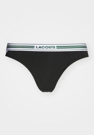 Čierne bikiny s jemnou tkaninou, so zeleno-bielym pruhovaným pásom s nápisom "LACOSTE" v zelenej farbe.