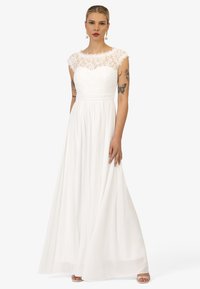 Witte jurk met een kanten lijfje met korte mouwen, een aangesloten taille en een vloeiende rok. De jurk heeft een zachte textuur en een elegante silhouet.
