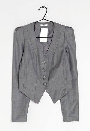 Grauer maßgeschneiderter Blazer mit vier Knöpfen, strukturierten Schultern, Reverskragen und zwei Fronttaschen, hängend an einem schwarzen Kleiderbügel.