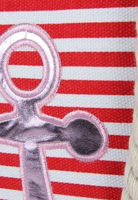 Tejido a rayas rojas y blancas con un diseño de ancla metálica en rosa, con bordado texturizado y un acabado suave y brillante.