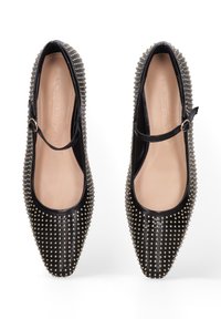 Zwarte lakleren ballerina's met een spitse teen, met zilveren studs langs de randen en een Mary Jane-band met een gesp.