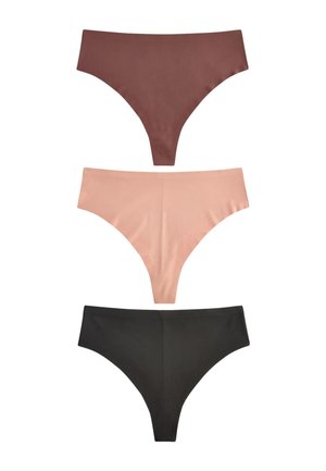 Kobieta w bezszwowej, wysokociętej bieliźnie w kolorze nude i dopasowanym biustonoszu, prezentująca środkową część ciała i górną część ud na jednolitym tle.