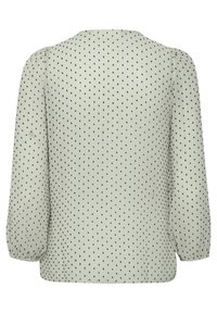 Blouse gris clair à manches longues avec petit motif à pois noirs et poignets élastiques, vue de dos.