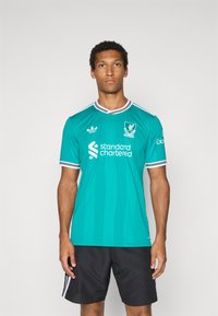 Teal sportsdrakt med korte ermer, hvite detaljer og vertikale striper. Har Liverpool FC-emblem og sponsorlogo på forsiden.