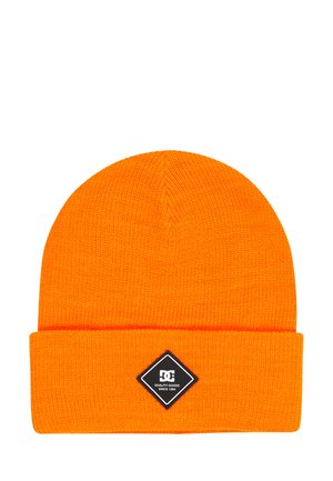 Heldere oranje gebreide muts met omgeslagen rand en zwarte vierkante patch met de tekst "DC Quality Goods Since 1994" centraal aan de voorkant.