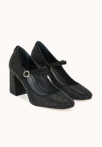 Chaussures à talons noires à bout pointu, avec une bride sécurisée et recouvertes de petits strass. Tissu texturé et design à talon bloc.