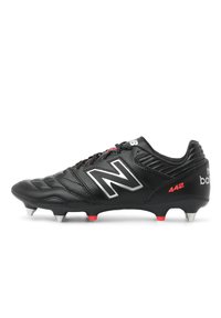Black leather soccer cleat with red and silver accents. Features a textured upper, cushioned collar, and nine molded studs for traction.