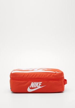 Prostokątny pomarańczowy woreczek Nike z białym logo z boku i na górze, zamknięcie na zamek błyskawiczny i mała rączka na jednym końcu.
