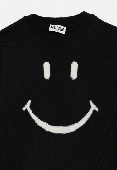 Svart strikket genser med stort hvitt smilefjesdesign og en Moschino Kid-label i kragen.