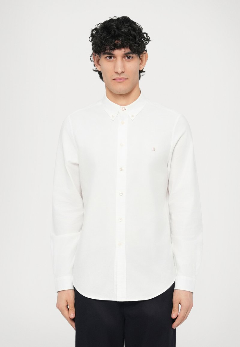 Camicia bianca a maniche lunghe con collo button-down e piccolo logo sul petto, realizzata in tessuto di cotone liscio. Taglio dritto e design classico.