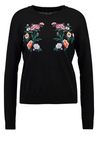 Musta neulottu villapaita, jossa on kirjailtuja kukkakuvioita vaaleanpunaisessa, oranssissa ja violetissa. Siinä on pyöreä kaula-aukko, pitkät hihat ja istuva vyötärö.