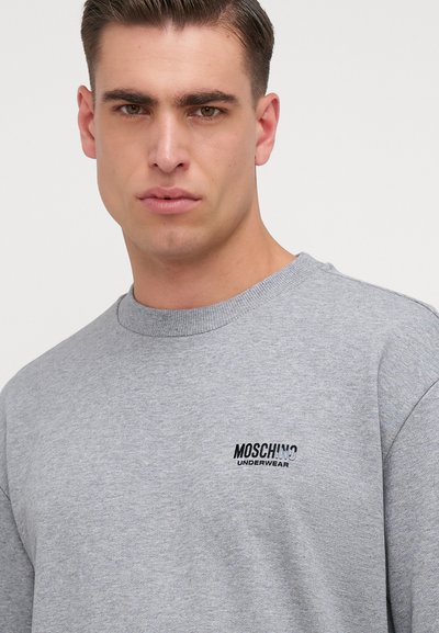Sivá mikina vyrobená z mäkkej látky, s rebrovaným výstrihom a čiernym logom "Moschino Underwear" na hrudi. Klasický strih.