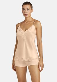 Camisole en satin pêche avec dentelle, dotée de bretelles ajustables, d'un décolleté en V et d'un ourlet en dentelle festonné. Tissu lisse et léger.