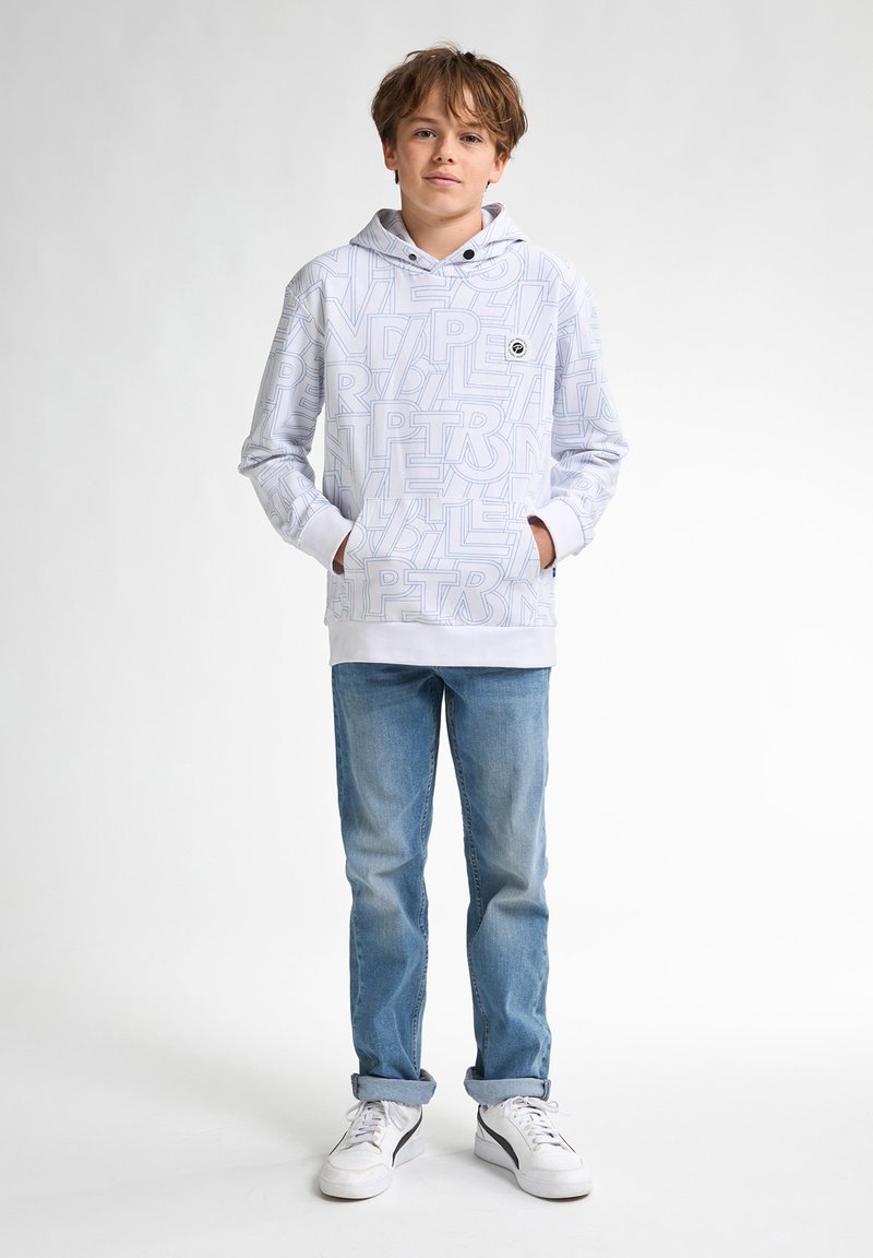Witte hoodie met lichtblauwe tekstpatronen, voorzak en trekkoordkap, gecombineerd met lichtblauwe jeans en witte sneakers.
