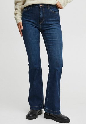 Dark blue denim flared jeans with a high waist, featuring copper hardware and subtle stitching details. Textured fabric with a smooth finish.