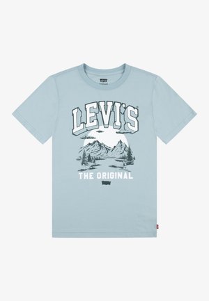 Jasnoniebieska koszulka Levi's z grafiką góry, drzew, chmur, dużym napisem "LEVI'S" u góry i napisem "THE ORIGINAL" na dole.
