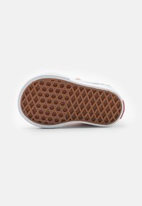 Gummisula med hexagonalt mönster, med brun bas och vita kanter. Strukturerad för grepp, inga synliga märkningar eller logotyper.