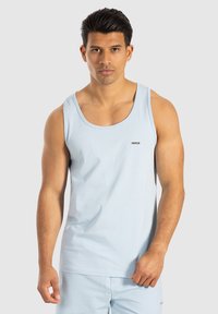 Lichtblauwe katoenen tanktop met ronde halslijn en mouwloos ontwerp. Heeft een klein merkimpressie op de borst. Gladde textuur.
