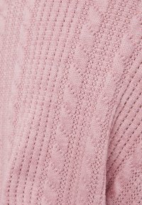 Maglione a maglia cable in rosa soffice. Presenta una texture a coste verticali e dettagli di pattern intricati. Realizzato in materiale knit leggero.