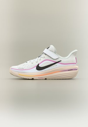 Biały but sportowy z czarnym logo Nike, różowymi i pomarańczowymi akcentami, siateczkową cholewką, sznurowaniem i paskiem na rzep oraz wyściełaną podeszwą.