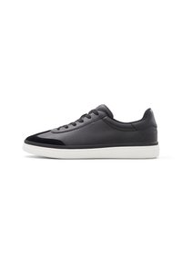 Zapatillas de piel negra con un upper liso, acentos de ante y suela de goma blanca. Clásico diseño de cordones con punta redondeada y estilo minimalista.