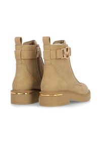 Béžové kotníkové boty z semiše s bočním zipem, zlatými kovovými doplňky a masivním podpatkem se metalickým akcentem.