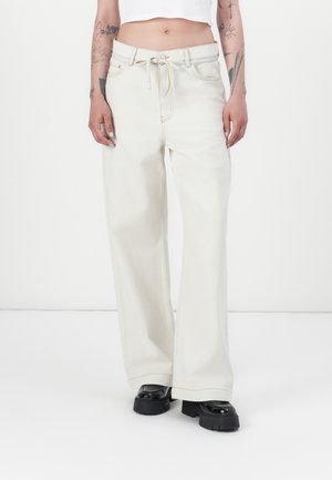 Bredde ben, lysebeige denim bukser med snor i midjen, fullført med kontrasterende sømmer og store sid lommer.