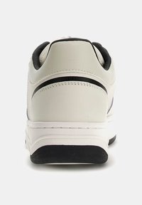 Sneaker bianco con tomaia in pelle liscia, dettagli neri sul tallone e sulla suola, e un intersuola imbottita per il massimo comfort.