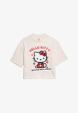 Camiseta blanca recortada con un gráfico impreso de Hello Kitty, que presenta acentos rojos y corazones, cuello redondo y mangas cortas.