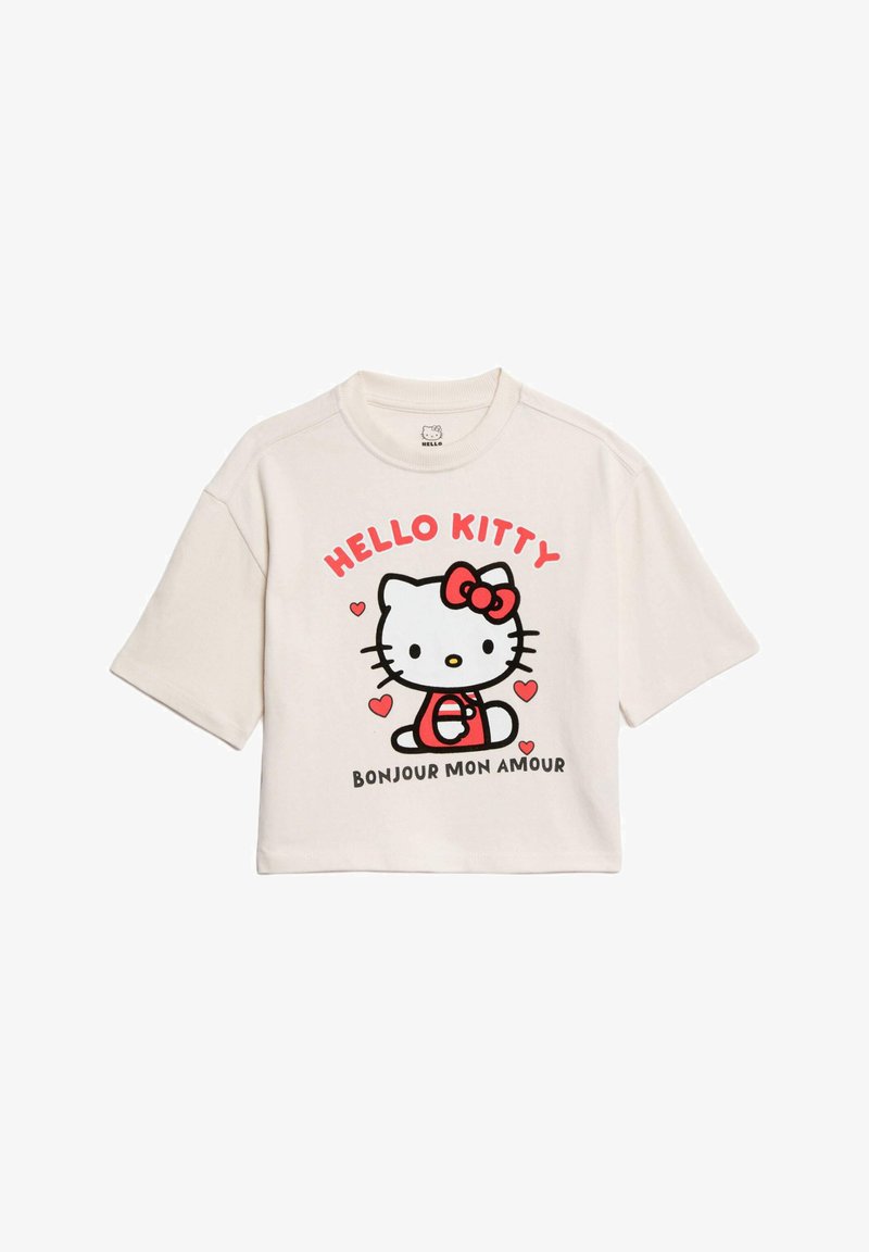 Geknipte witte t-shirt met een afgedrukte Hello Kitty afbeelding, met rode accenten en harten, ronde halslijn en korte mouwen.