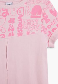 Lyserød t-shirt med ribbet tekstur og iøjnefaldende pink grafiske mønstre med mærkenavnet "Desigual" på den øverste del. Korte ærmer.