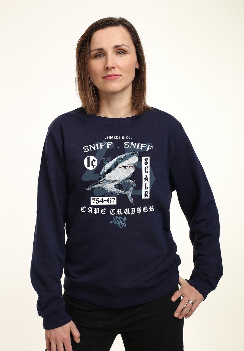 Dunkelblaues Sweatshirt mit einem Grafikdesign eines Hais und weißem sowie hellblauem Text, der "SHARKY & CO. SNIFF . SNIFF SCALE 754-67 CAPE CRUISER." lautet.