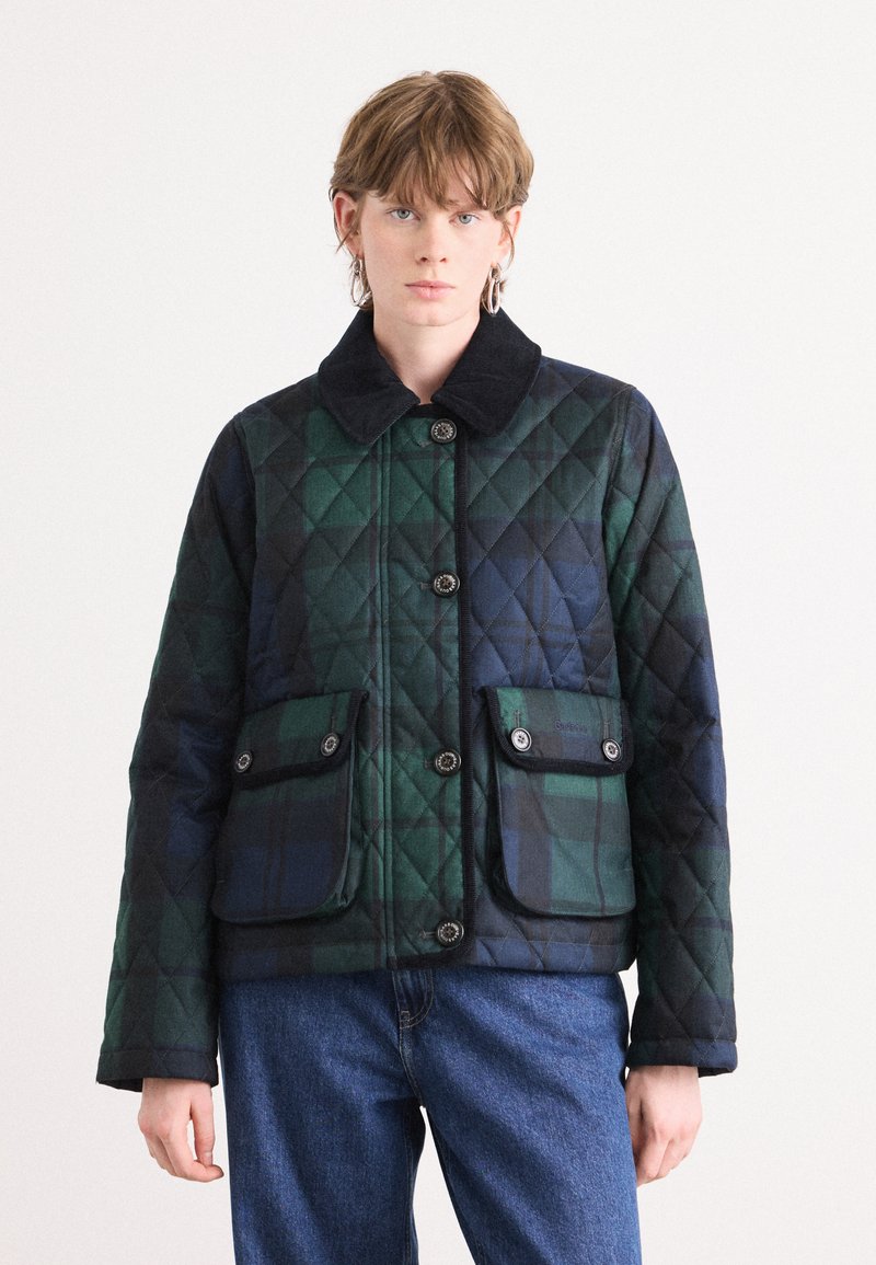 Gequilte jas in donkergroen en marineblauw ruitpatroon, met een zwarte corduroy kraag, twee voorzakken met knoopsluitingen en een knoopsluiting aan de voorkant.