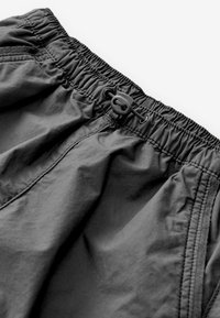 Blå shorts med elastisk talje og snøre, der har en glat tekstur og let materiale, og som fremviser et enkelt, funktionelt design.