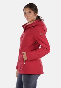 Giacca impermeabile rossa con cappuccio, frontale con zip, tasche laterali e polsini elastici, caratterizzata da un design elegante e una morbida texture del tessuto.