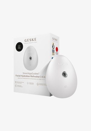 Dispositif d'hydratation faciale blanc en forme d'œuf GESKE avec buse centrale, à côté de sa boîte affichant le nom du produit, les caractéristiques et le badge de nomination au prix du design 2024.