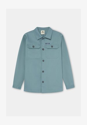 Camisa azul claro abotonada, con dos bolsillos en el pecho con solapas, cuello redondo, mangas largas y dobladillo redondeado. Hecha de tela texturizada.