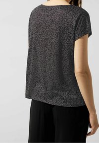 Černé a šedé tričko s leopardím potiskem a krátkým rukávem, volného střihu a širokým výstřihem. Lehká, poloprůhledná textura.