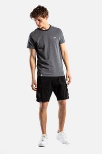 Camiseta gris con cuello redondo y logo, combinada con pantalones cortos cargo negros con bolsillos. El modelo lleva zapatillas blancas.