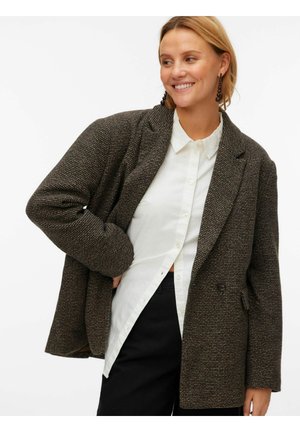 Rjav teksturiran prevelik blazer z zarezo na klopčiču, dvorednim zapiranjem na gumbe in sprednjimi žepi, v kombinaciji z belo srajco na gumbe.