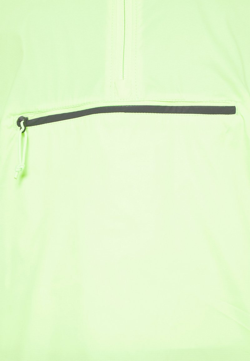 Sudadera con cremallera de color verde claro, con un bolsillo horizontal negro en contraste y detalles de cordón. Fabricada con un tejido suave y ligero.