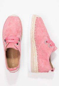 Chaussures à lacets en daim rose avec des semelles épaises blanches et tressées, œillets en métal, et taille 37 visible à l'intérieur d'une chaussure.